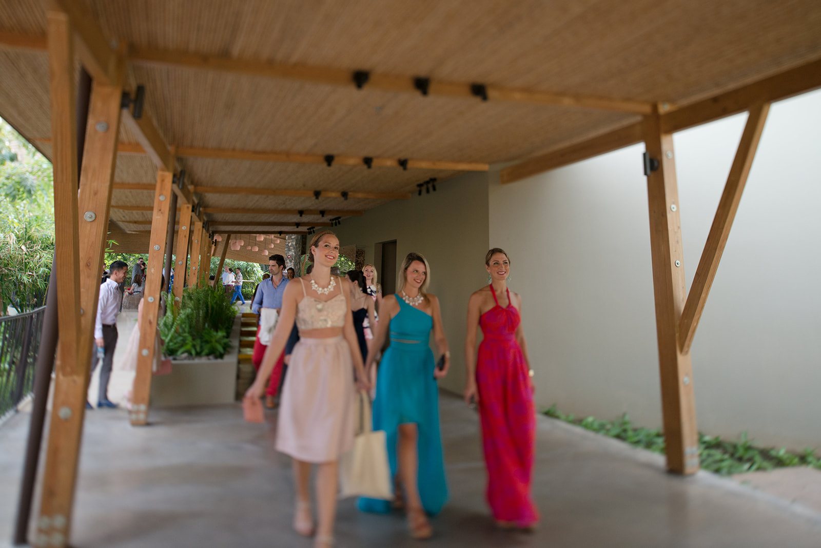 The bridesmaids in bright gowns under the walkway