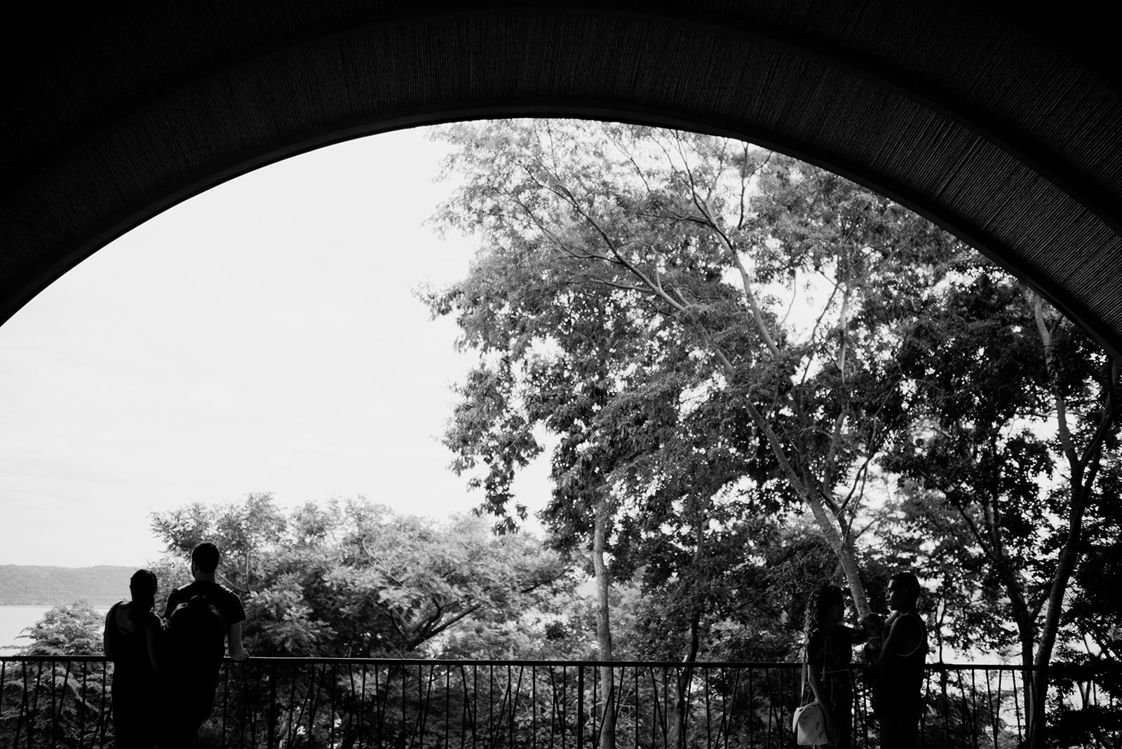 Guests under the arched walkway, in black and white