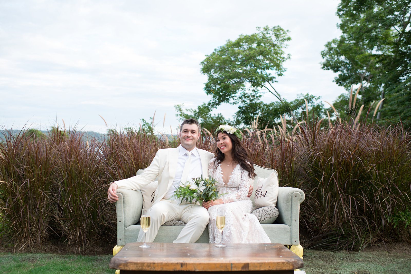 The couple on a white sofa in the tall grass