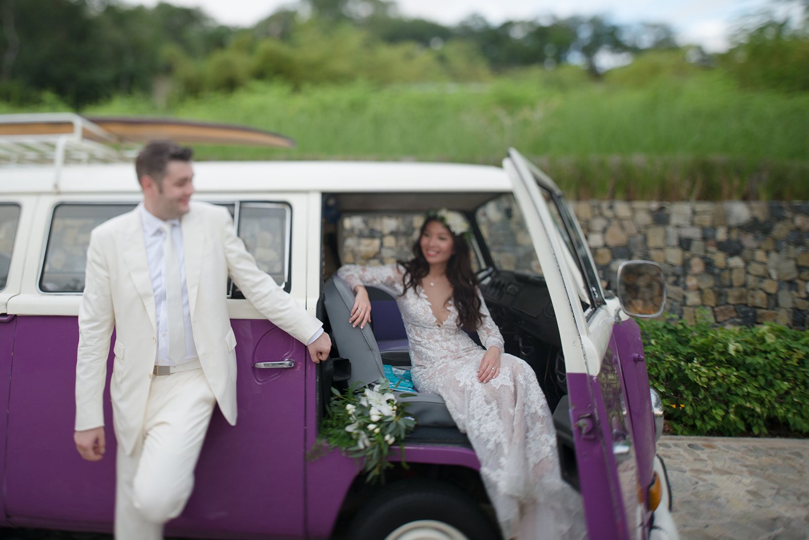 The groom helping the bride out of the van