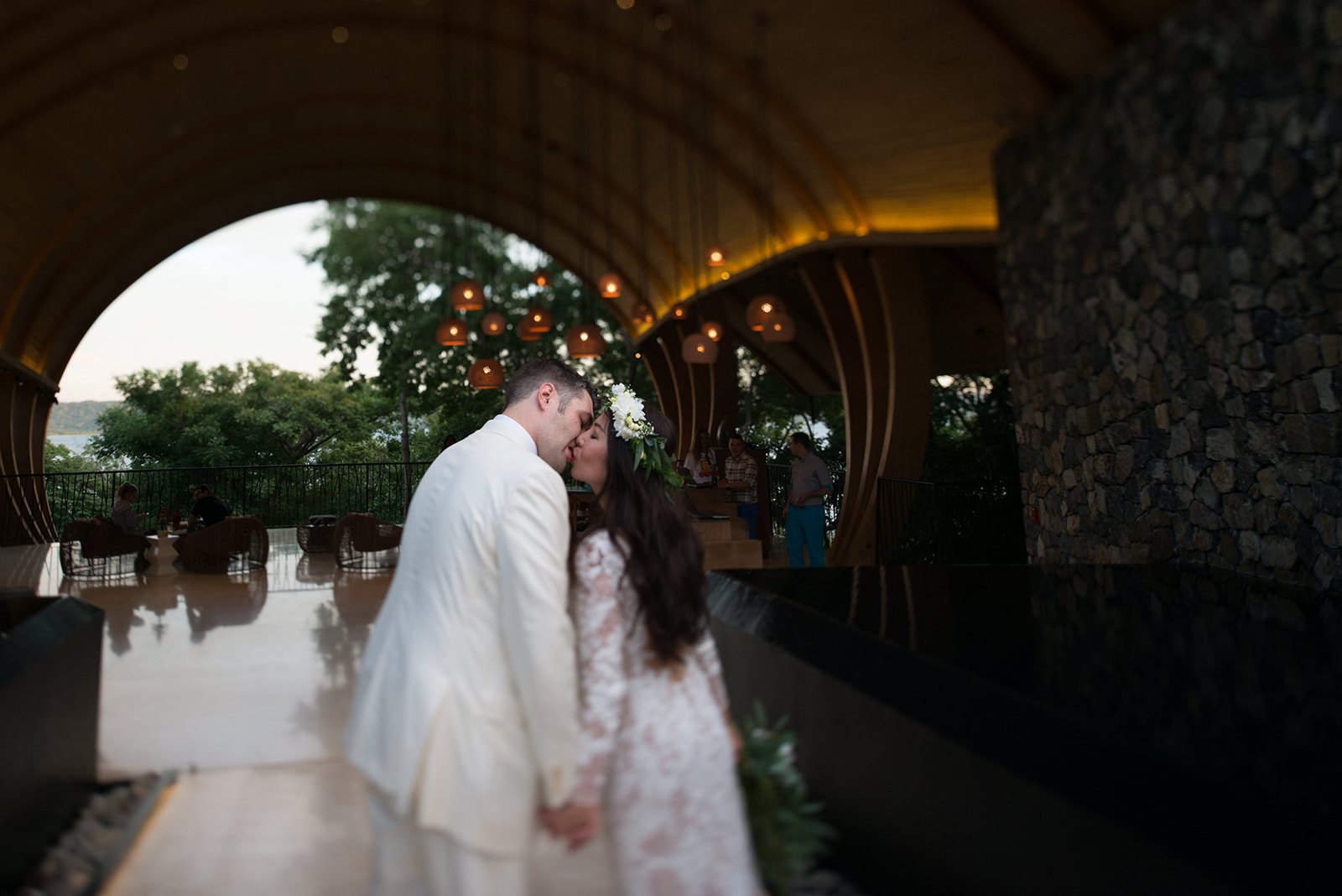 The couple under the curved entry at dusk