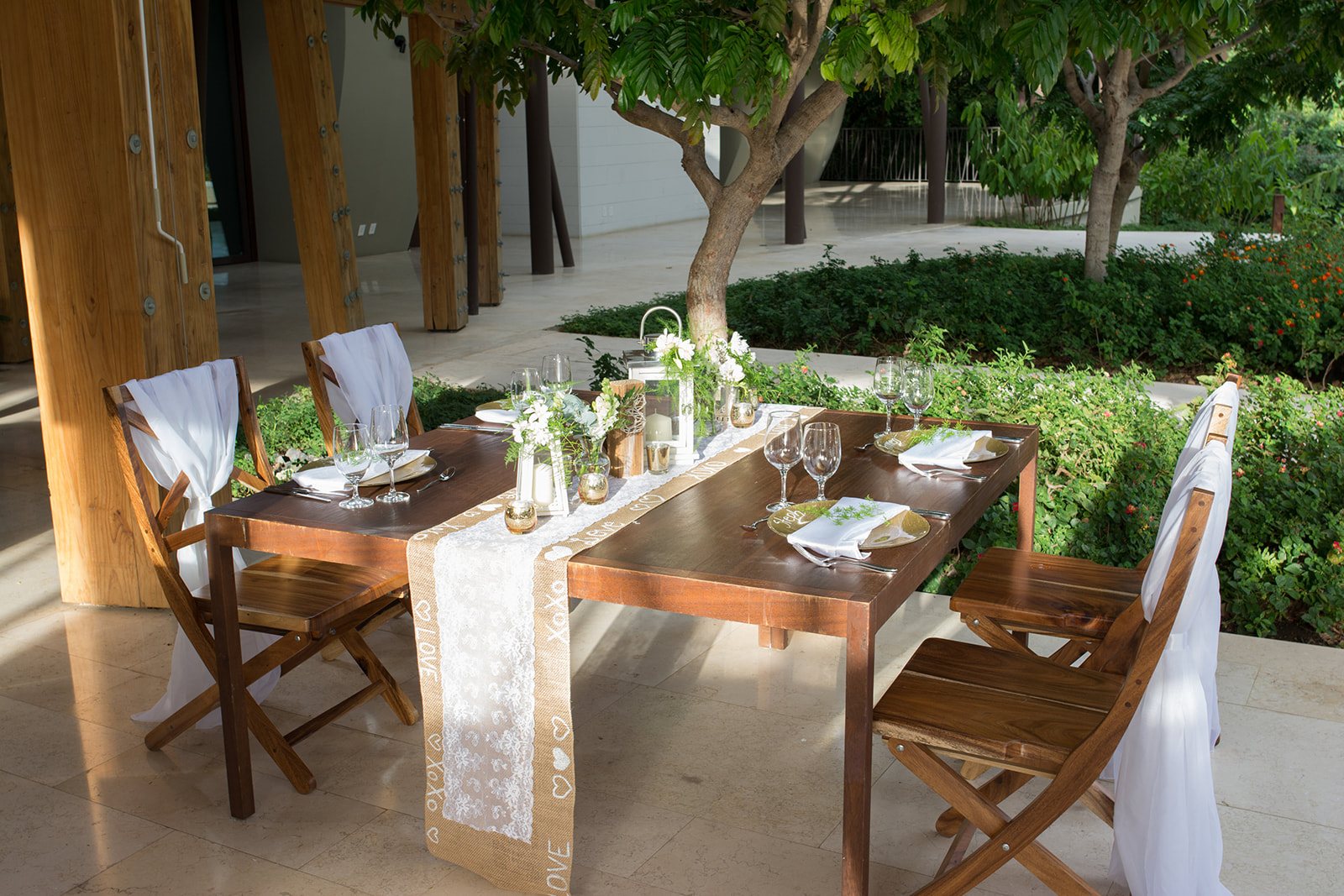 A wooden reception table with runners and greenery