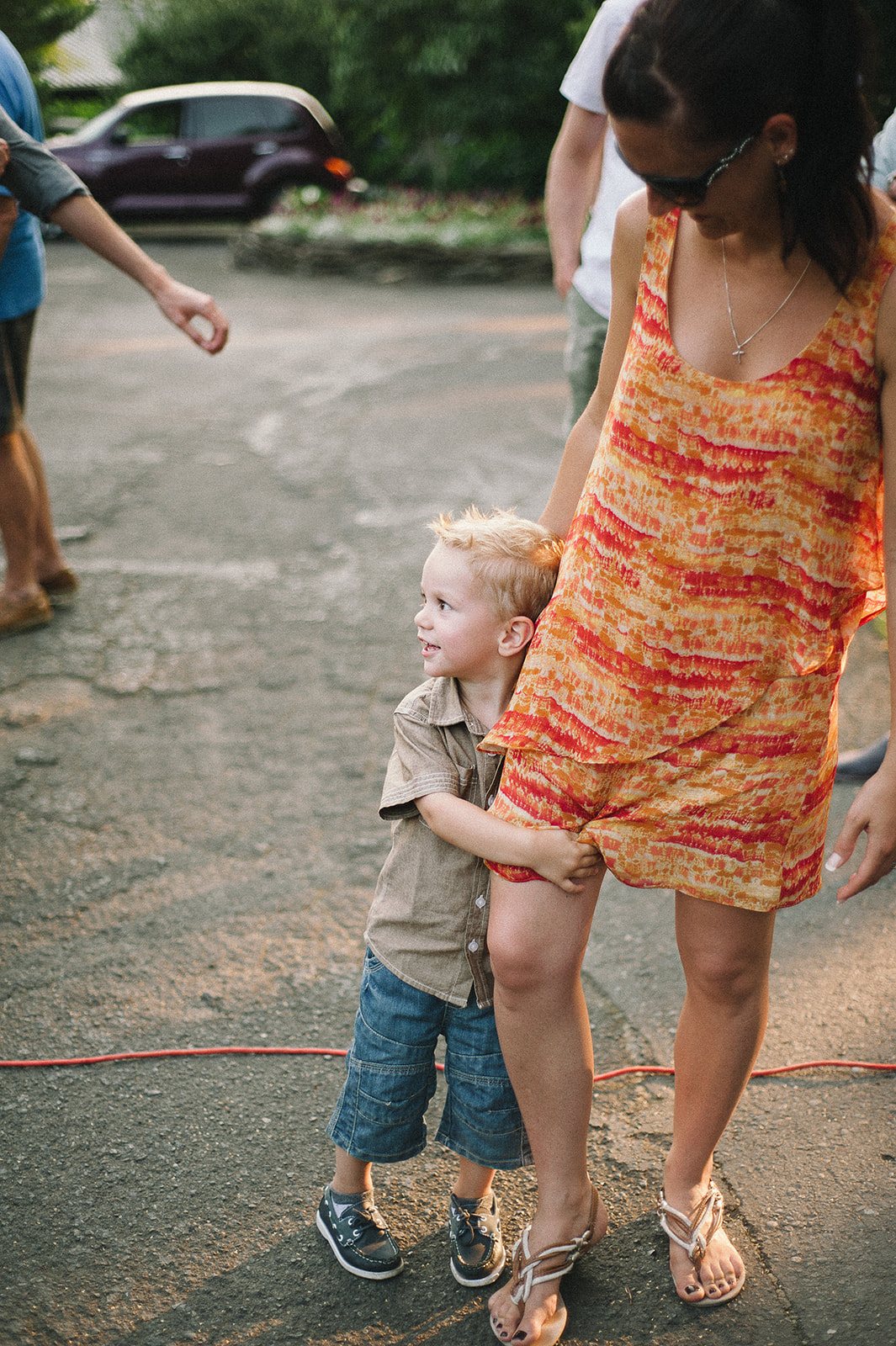 A small boy holding his mother's hand