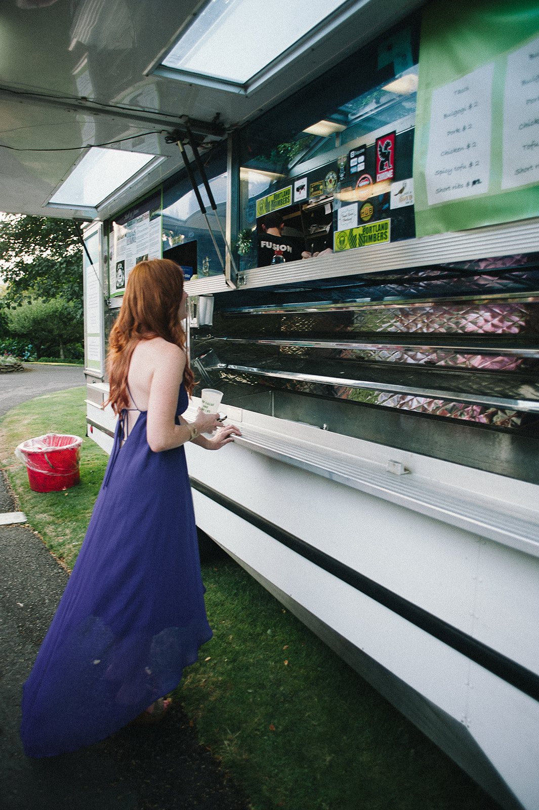 A guest in a long blue dress at the food truck window