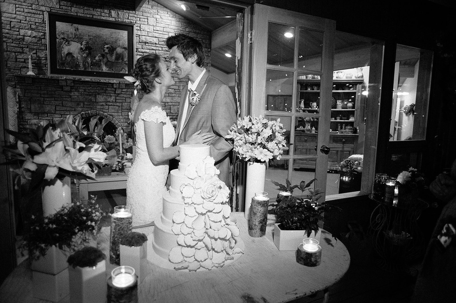The couple cutting the cake, in black and white